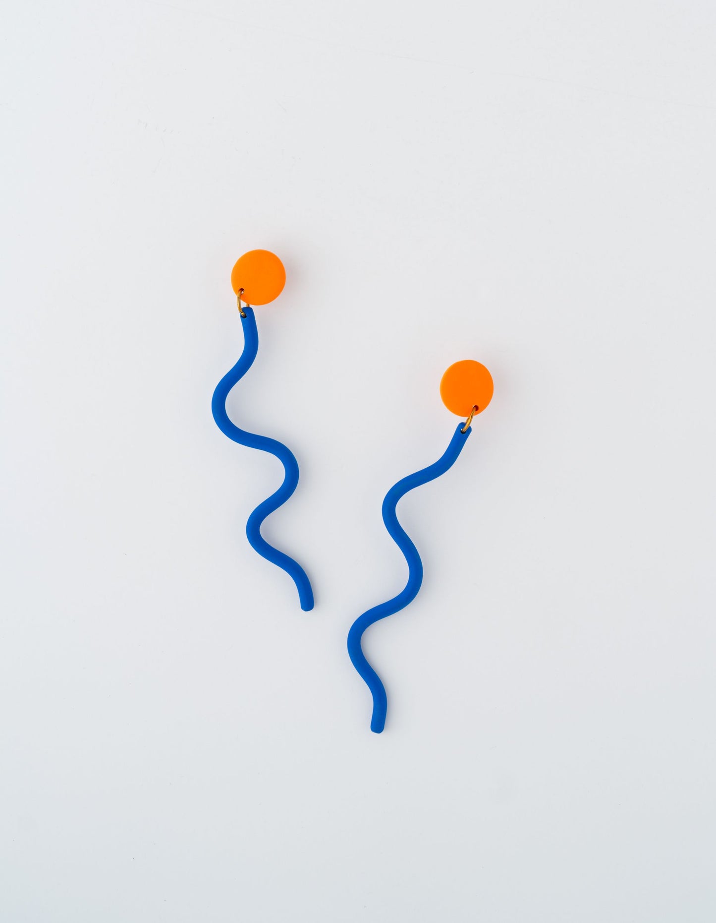 Light Snake earrings by APÖ, handmade polymer clay earrings featuring a long, wavy snake-like shape with a contrasting circular accent, large, colorful, and ultra-lightweight.