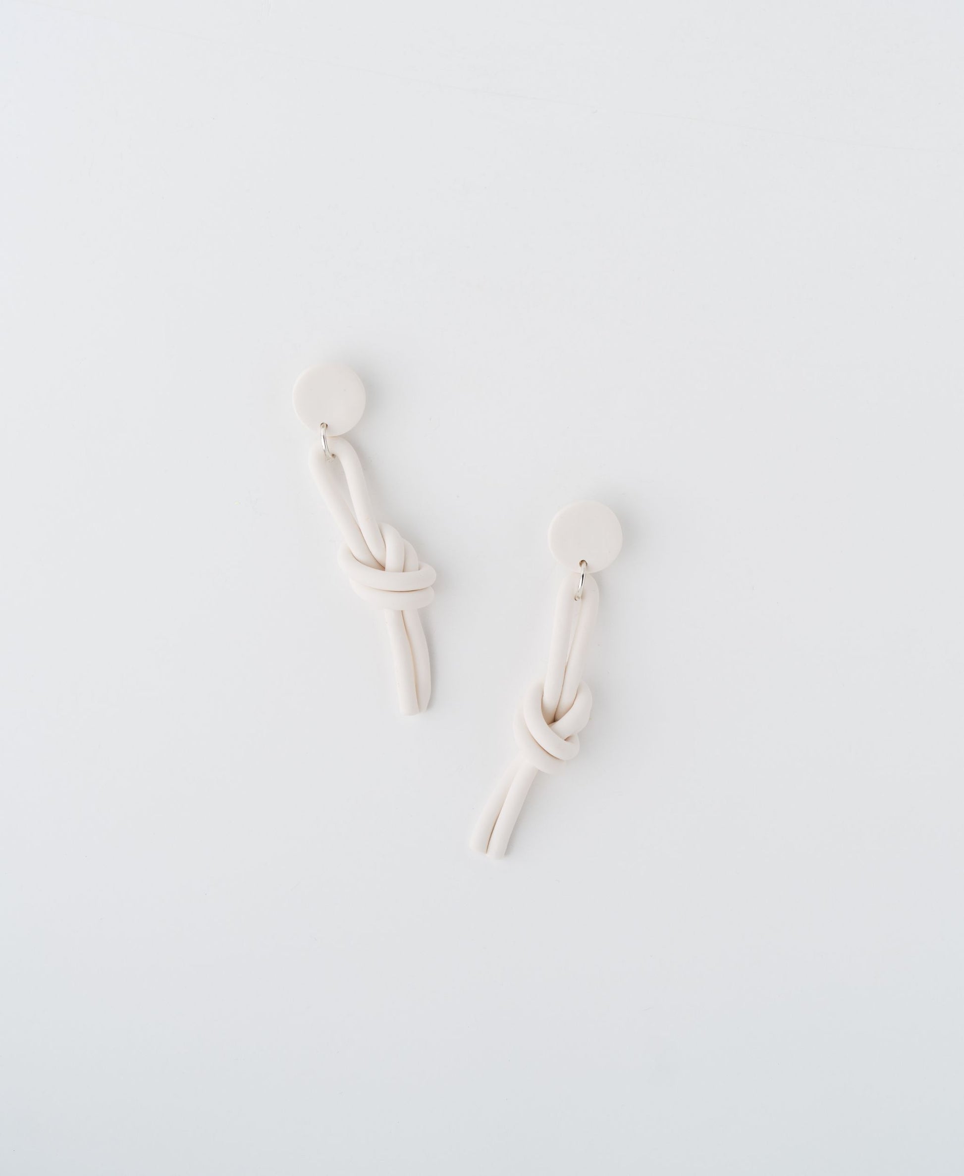 Abrazo earrings by APÖ, handmade polymer clay earrings with a sculptural knotted shape, artistic, lightweight, and customizable in color.