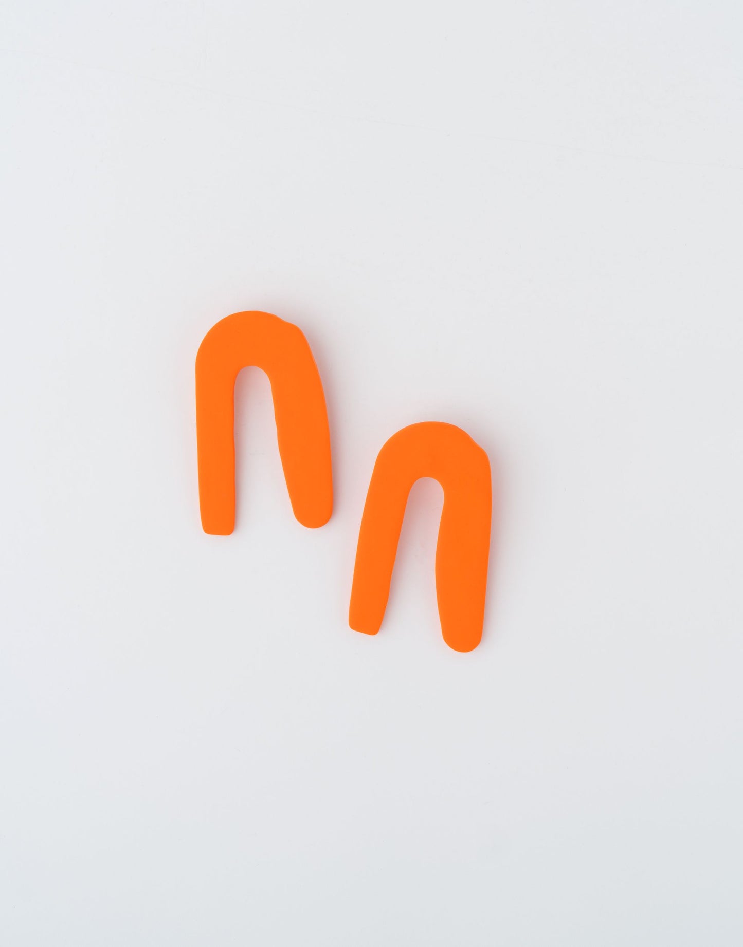 Altitude earrings by APÖ, handmade polymer clay earrings featuring a smooth, bold arch design in a single color, medium-sized, minimal and lightweight.
