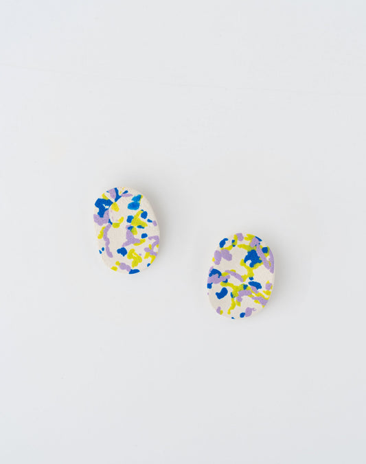 Hojita earrings by APÖ, handcrafted polymer clay earrings featuring artistic  design in blue, green, and purple details over a white base, medium-sized and lightweight.