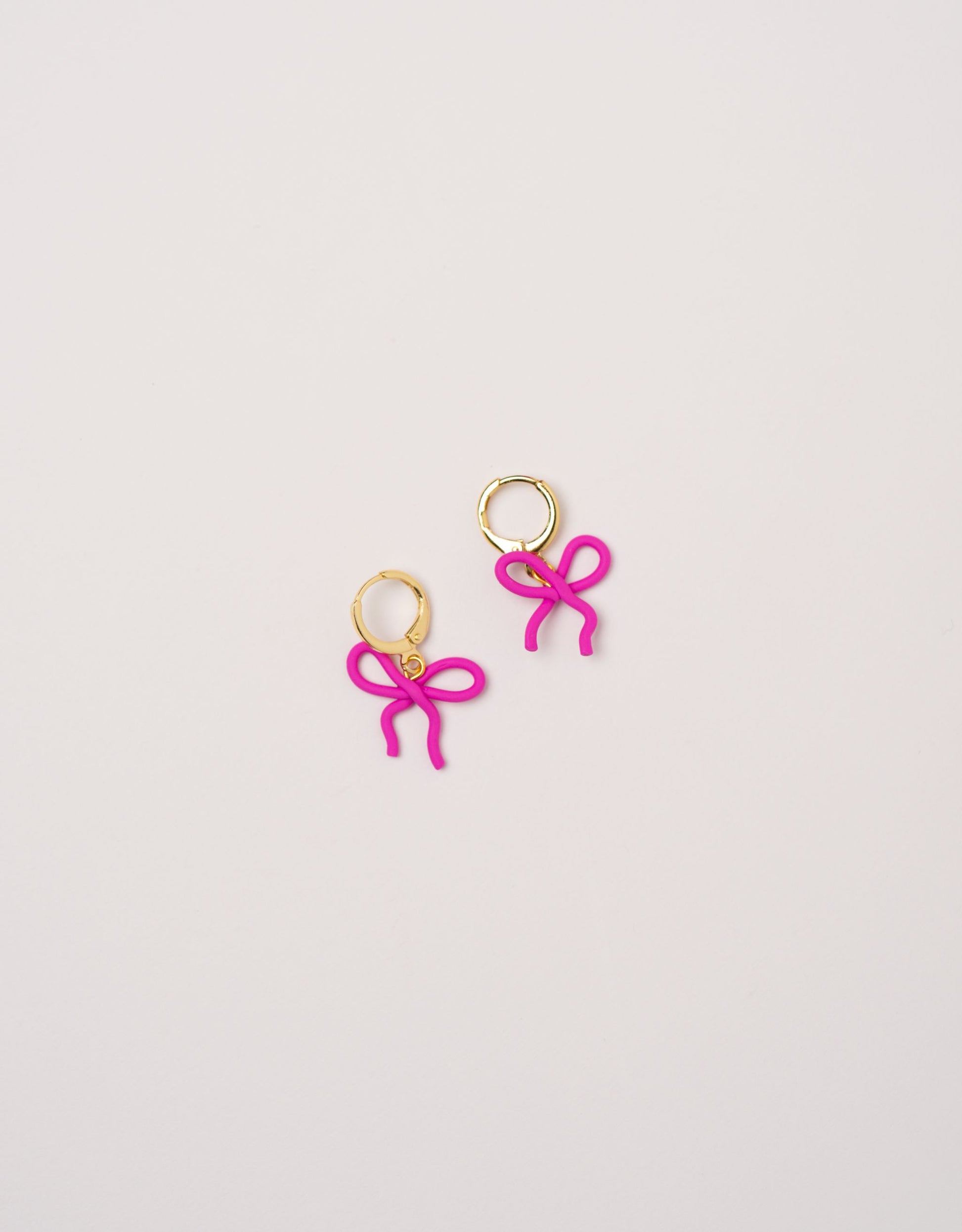 Wavy Bow earrings by Little APÖ, handmade polymer clay earrings in a small wavy ribbon shape, unicolor, lightweight, and designed for young girls.